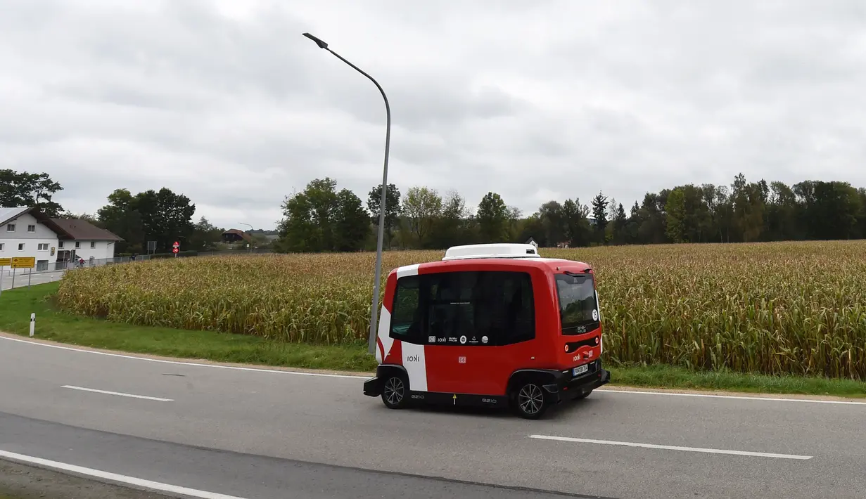 Bus tanpa sopir alias bus otonom melaju di dekat stasiun kereta api Bad Birnbach, Jerman selatan, pada 7 Oktober 2019. Keberadaan bus tanpa sopir ini penting bagi daerah pinggiran lantaran orang lebih suka bepergian menggunakan mobil karena jarangnya transportasi umum. (Christof STACHE / AFP)