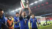 Pemain Italia Jorginho berselebrasi memegang trofi usai pertandingan final Piala Eropa 2020 melawan Inggris di Stadion Wembley, London, Senin, 12 Juli 2021. Italia menang 3-2 (1-1) lewat adu penlti. (Andy Rain/Pool Photo via AP)