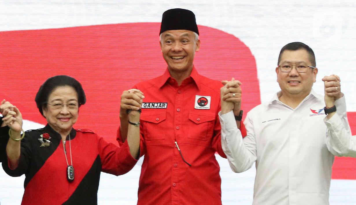 Ketua Umum PDIP Megawati Soekarnoputri (kiri) bersama Ketua Umum Partai Perindo Hary Tanoesoedibjo (kanan) dan Bakal calon presiden Ganjar Pranowo mengangkat tangan usai penandatanganan kerja sama politik di Kantor DPP PDIP, Jakarta, Jumat (9/6/2023). (Liputan6.com/Herman Zakharia)
