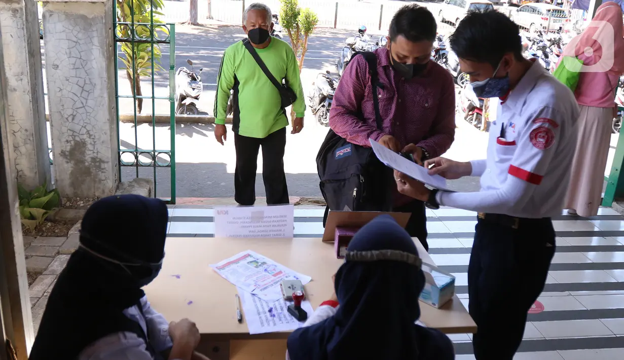 Petugas memeriksa Surat Tanda Registrasi Pekerja (STRP) bagi penumpang di Stasiun Tangerang, Banten, Senin (12/7/2021). Kementerian Perhubungan mengeluarkan aturan soal kewajiban membawa surat tanda registrasi pekerja (STRP) dan/atau surat tugas bagi pengguna KRL. (Liputan6.com/Angga Yuniar)