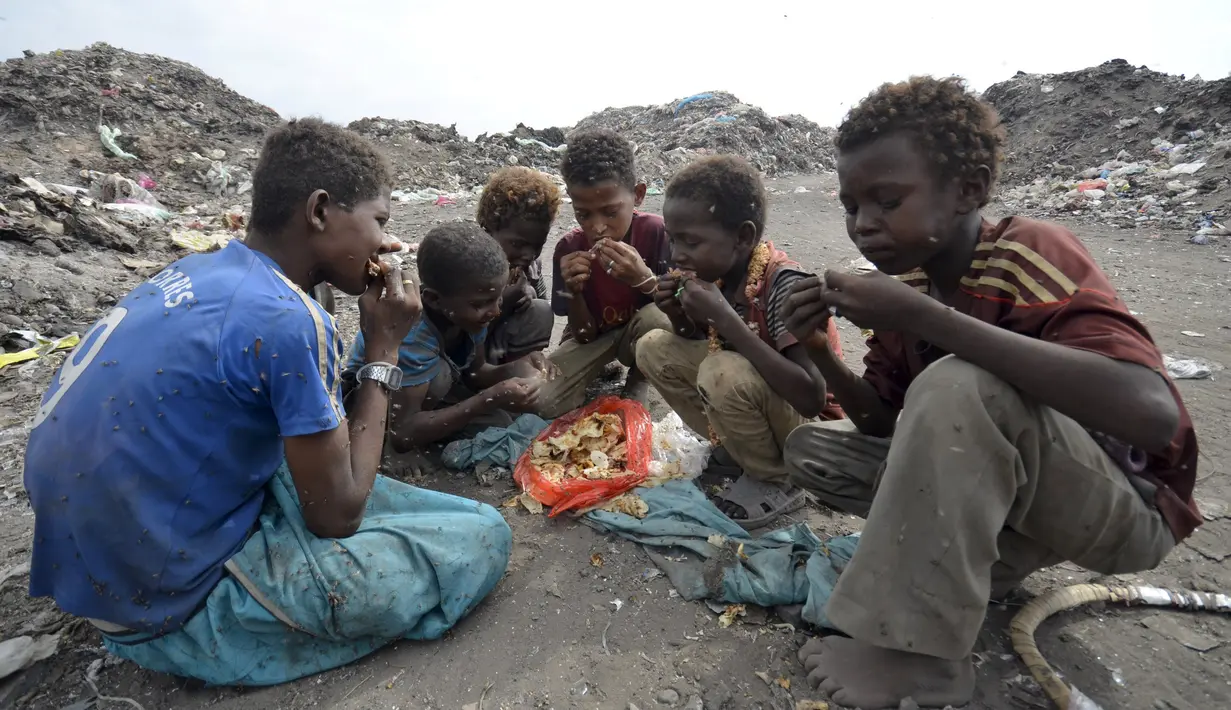 Sejumlah anak laki-laki makan bersama usai mengumpulkan sampah untuk didaur ulang di tempat pembuangan sampah di kota Houdieda, Yaman, Rabu (20/1). (REUTERS/Abduljabbar Zeyad)