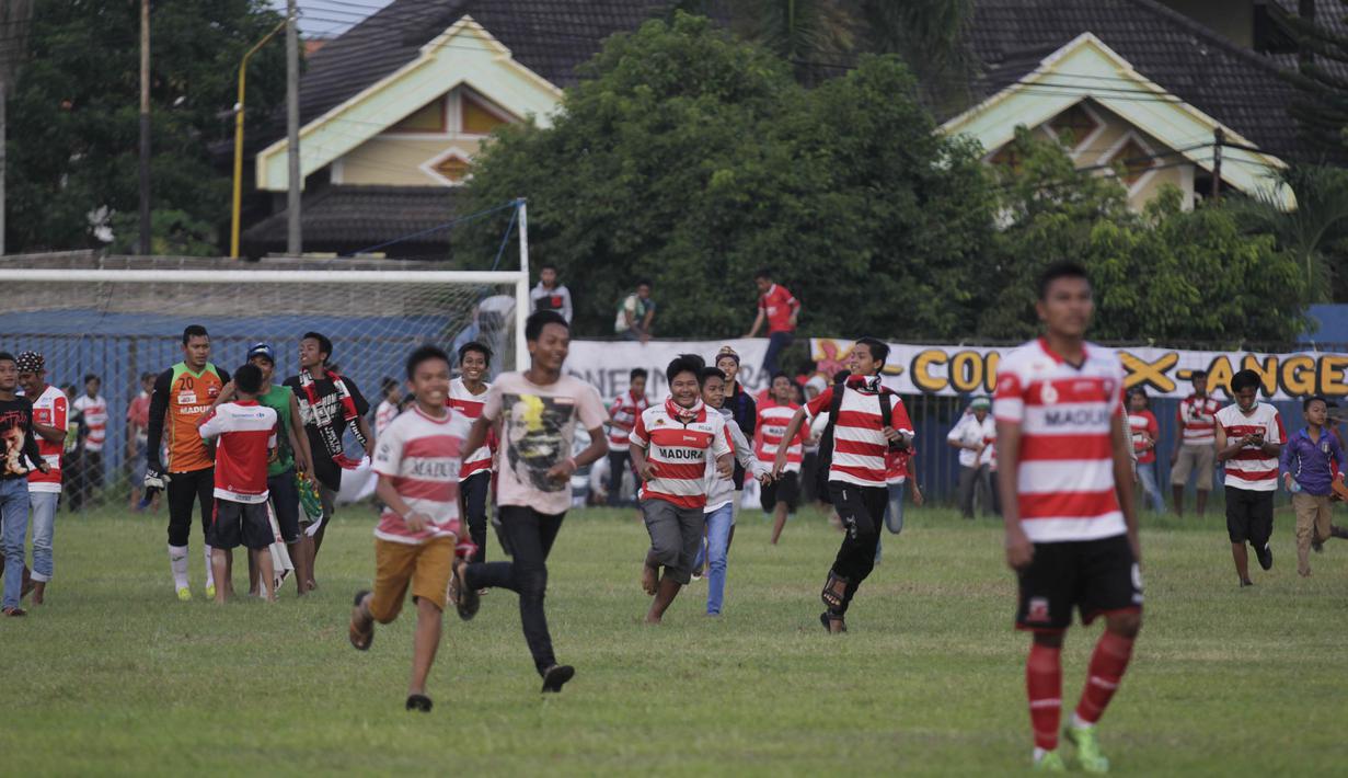 Para penonton masuk ke lapangan usai laga berakhir untuk menyapa dan meminta selfie para pemain Madura United. (Bola.com/Vitalis Yogi Trisna)