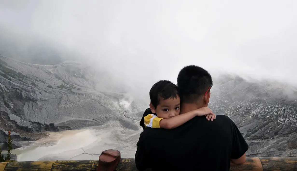 Seorang pengunjung menikmati keindahan suasana Taman Wisata Alam Gunung Tangkuban Perahu. (Liputan6.com/Johan Tallo)