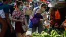 Seorang perempuan dengan masker membeli sayuran, setelah pelonggaran pembatasan karantina wilayah (lockdown), di pusat kota Manila, Filipina, Rabu (2/9/2020). Pemerintah melonggarkan lockdown meskipun negara tersebut memiliki infeksi virus corona terbanyak di Asia Tenggara. (AP Photo/Aaron Favila)