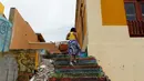 Wisatawan menyentuh air kolam buatan di La Perla, yang menjadi lokasi syuting video klip Despacito, di San Juan, Puerto Rico 22 Juli 2017. Lagu Despacito membangkitkan minat wisatawan asing untuk melihat tempat lahir dua penyanyinya (Ricardo ARDUENGO/AFP)