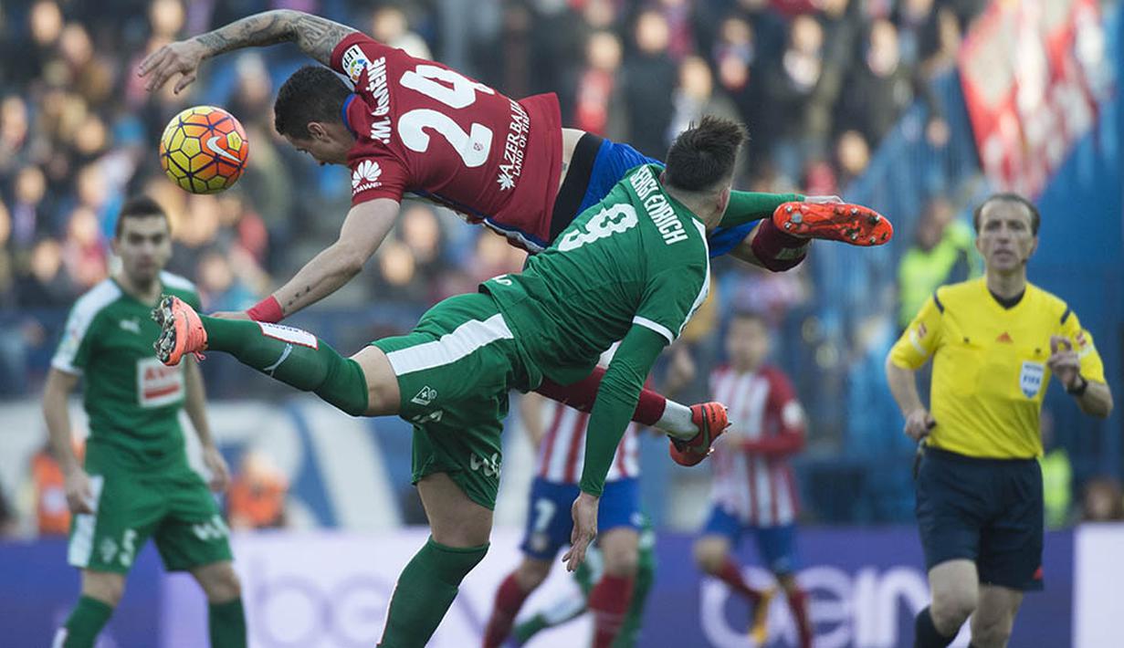 Bek Atletico Madrid, Jose Gimenez, duel udara dengan striker Eibar, Sergi Enrich pada laga La Liga di Stadion Vicente Calderon, Spanyol, Sabtu (6/2/2016). Atletico Madrid berhasil menaklukan Eibar 3-1. (AFP/Curto De La Torre)