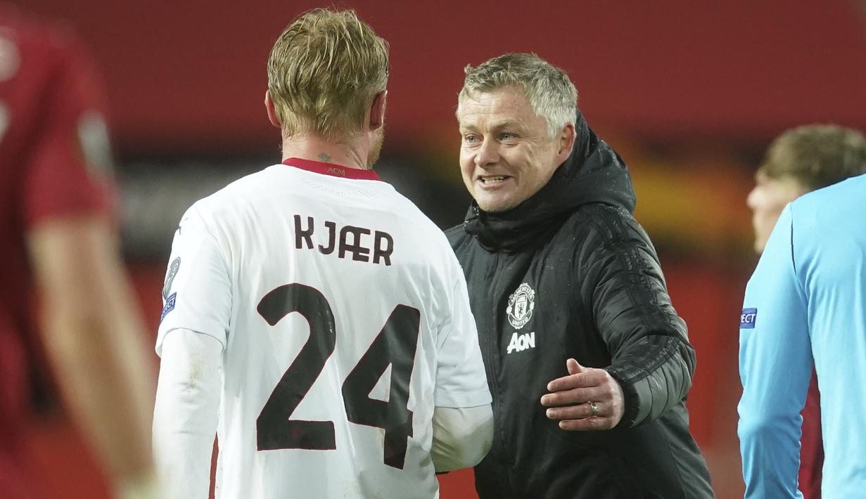 Pelatih Manchester United, Ole Gunnar Solskjaer menyapa bek AC Milan, Simon Kjaer usai pertandingan leg pertama babak 16 besar Liga Europa di Old Trafford, Inggris, Jumat (12/3/2021). Milan berhasil mencuri satu gol tandang yang akan jadi modal berharga untuk leg kedua. (AP Photo/Dave Thompson)
