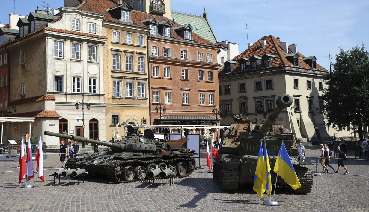 Orang-orang mengunjungi pameran terbuka tank dan kendaraan lapis baja Rusia yang rusak dan terbakar di Castle Square, di Warsawa, Polandia (27/6/2022). Kendaraan tersebut ditangkap oleh pasukan militer Ukraina selama perang di Ukraina. (AP Photo/Michal Dyjuk)