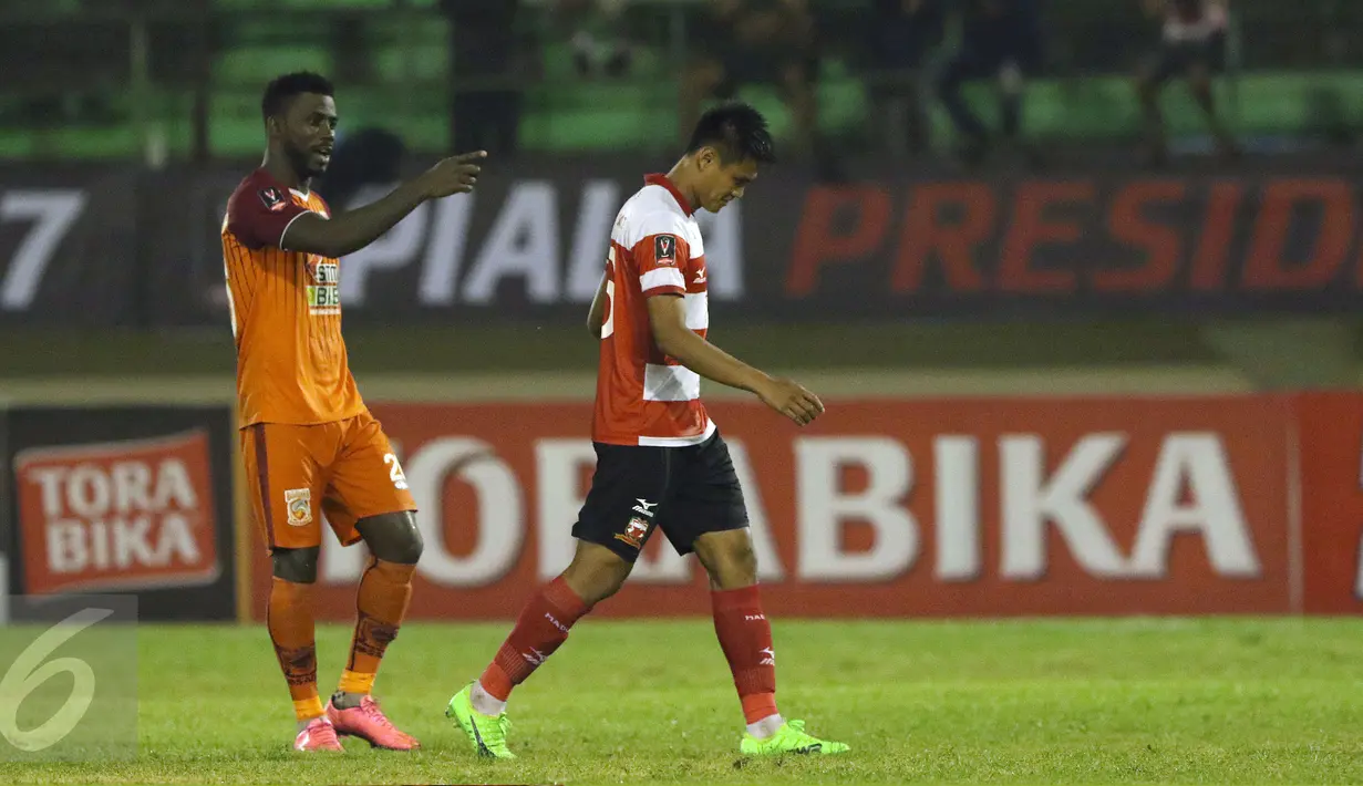 Pemain belakang PBFC, Dirkir Kohn Glay (kiri) menunjuk Fachrudin WA (Madura United) yang akan melakukan tendangan penalti saat laga 8 besar PIala Presiden 2017 di Stadion Manahan Solo, Sabtu (25/2). PBFC unggul 5-4 (0-0). (Liputan6.com/Helmi Fithriansyah)