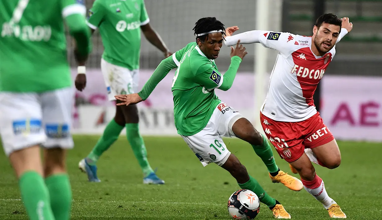 Gelandang Saint-Etienne, Yvan Neyou (kiri) berebut bola dengan striker AS Monaco, Kevin Volland dalam laga lanjutan Liga Prancis 2020/2021 pekan ke-30 di Geoffroy Guichard Stadium, Jumat (19/3/2021). Saint-Etienne kalah 0-4 dari Monaco. (AFP/Jeff Pachoud)