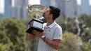 Petenis Serbia, Novak Djokovic mencium piala juara tunggal putra Australia Terbuka 2020 saat sesi pemotretan di Royal Botanic Gardens Victoria, Melbourne, Australia, Senin (3/2/2020). Bagi Novak Djokovic, ini merupakan gelar Australia Terbuka kedelapan. (AP Photo/Dita Alangkara)