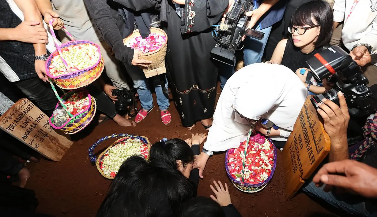 Terlihat ibunda dan kedua adik Jupe, Della dan Nia, tak kuasa menahan kesedihannya. Bahkan tanpa disadarinya, Della menangis sambil memeluk dan mengais-ngais bunga di atas makam kakak tercintanya. (Bambang E.Ros/Bintang.com)