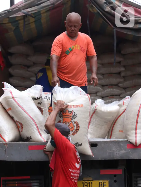 Pekerja tengah menurunkan beras yang akan di jual di Jakarta, Senin (21/12/2020). Kementerian Pertanian (Kementan) menyatakan, hasil proyeksi terakhir menunjukkan pergerakan harga beras cenderung stabil hingga Maret 2021. (Liputan6.com/Angga Yuniar)