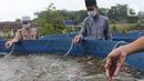 Santri memberi makan ikan mujair nila merah di budidaya ikan Pesantren Ruhama Al Fajar, Citayam, Bogor, Jawa Barat, Selasa (29/6/2021). Di Masa pandemi Covid-19 peran pemulihan ekonomi nasional kini menyasar ke pesantren dalam pemulihan ketahanan pangan. (merdeka.com/Arie Basuki)