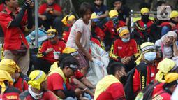 Pemulung berada di tengah-tengah aksi unjuk rasa di kawasan Patung Kuda, Jakarta, Selasa (10/11/2020). Beberapa pemulung mencoba peruntungan saat massa gabungan dari berbagai organisasi buruh dan mahasiswa berunjuk rasa menolak Omnibus Law UU Cipta Kerja. (Liputan6.com/Helmi Fithriansyah)