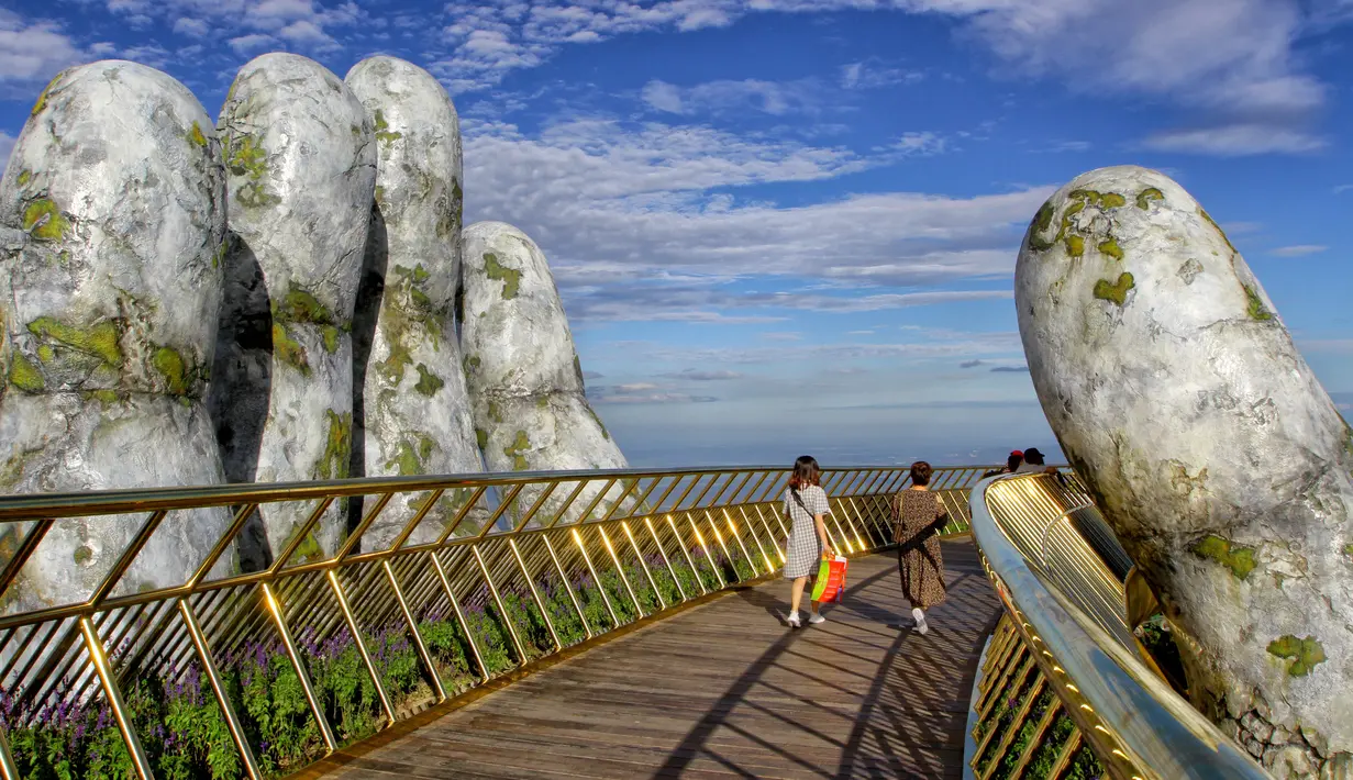 Pengunjung berjalan di sepanjang Golden Bridge di Perbukitan Ba Na dekat Danang, Vietnam, Selasa (31/7). Keunikan Golden Bridge telah menarik perhatian wisatawan berbagai belahan dunia. (Linh PHAM/AFP)
