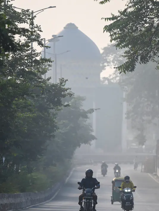 Kendaraan berjalan di sepanjang jalan di tengah kondisi kabut asap tebal di New Delhi (15/11/2021). Pemerintah kota New Delhi telah menutup sekolah-sekolah dan mempertimbangkan penguncian kota selama sepekan sejak Senin ini.  (AFP/Money Sharma)