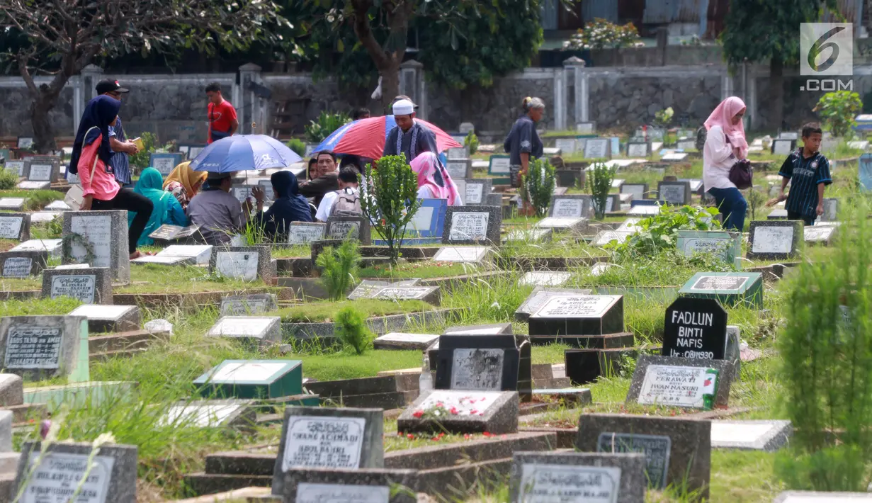 Warga berziarah di TPU Karet Pasar Baru Barat, Jakarta, Sabtu (16/6). Ziarah kubur atau "nyekar" pada hari raya lebaran merupakan salah satu tradisi umat muslim untuk mendoakan sanak keluarga yang meninggal dunia. (Liputan6.com/Arya Manggala)