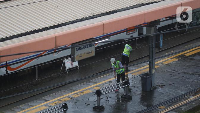 Petugas menyapu air yang menggenangi di peron Stasiun kereta Tanah Abang, Jakarta, Rabu (1/1/2020). Hujan yang mengguyur Jakarta sejak Selasa sore (31/12/2019) mengakibatkan rel terendam dan perjalanan kereta dari dan ke Stasiun Tanah Abang dihentikan. (Liputan6.com/Helmi Fithriansyah)