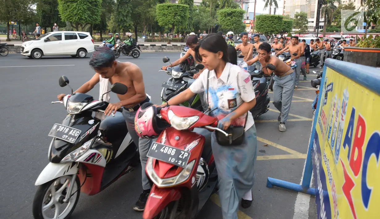 Ratusan pelajar SMA mendorong sepeda motor mereka di Bundaran Simpang Lima, Semarang, Jawa Tengah, Kamis (3/5). Selain mengganggu ketertiban umum, para pelajar diamankan karena membahayakan pengguna jalan lainnya. (Liputan6.com/Gholib)