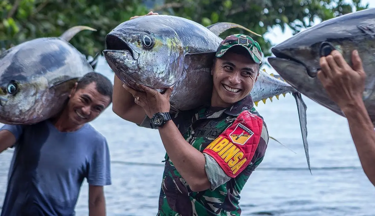 <p>Dengan senyum lebarnya, Aprilio Perkasa Manganang tampil kuat saat membantu nelayan membawa tuna sirip kuning yang berukuran besar. (FOTO: instagram.com/manganang92/)</p>