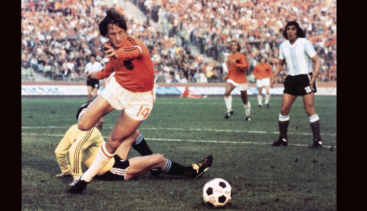 Gelandang Timnas Belanda, Johan Cruyff berhasil melewati kiper Argentina, Daniel Carnevali untuk mencetak gol pada laga perempatfinal Piala Dunia 1974 di Gelsenkirchen, Jerman (26/6/2974). Johan Cruyff mencetak satu gol dalam laga debutnya bersama Timnas Belanda saat bermain imbang 2-2 dengan Hongaria pada ajang kualifikasi Piala Eropa 1968 (7/9/1966). Legenda yang tutup usia pada 24 Maret 2016 ini total mengoleksi 48 caps dengan raihan 33 gol dan 30 assist. (AFP/Staff)