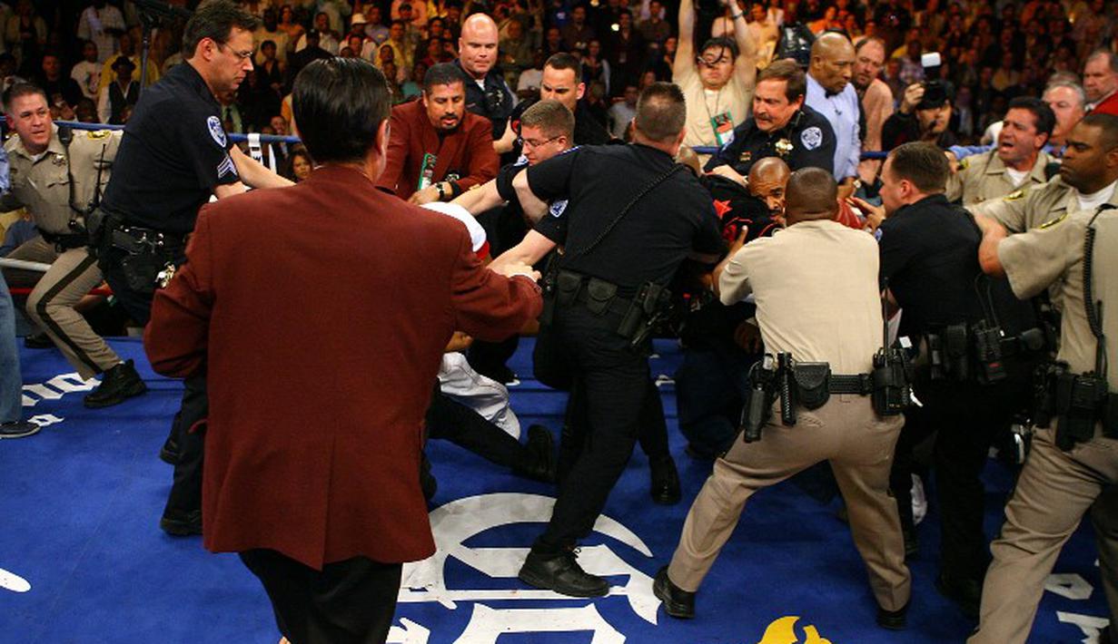 Polisi harus naik ke atas ring saat terjadi keributan di ronde 11 antara kubu Floyd Mayweather Jr. dan Zab Judah. Mayweather menang dan menjadi juara dunia baru Kelas Welter IBF. 8 April 2006. (AFP)