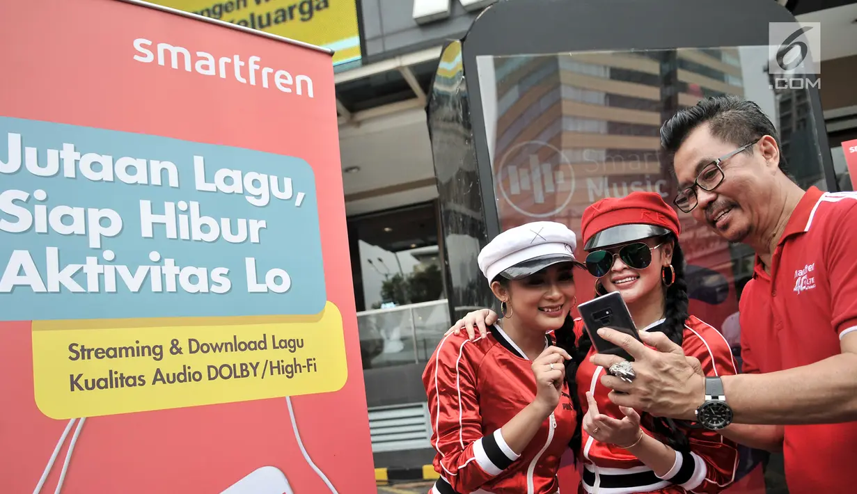 Deputy CEO Smartfren Djoko Tata Ibrahim bersama personel Duo Anggrek saat menggunakan aplikasi SmartMusic di Sarinah, Jakarta, Minggu (10/2). Paket langganan yang ditawarkan sangat terjangkau mulai dari Rp 1.000 per hari. (Merdeka.com/Iqbal S. Nugroho)