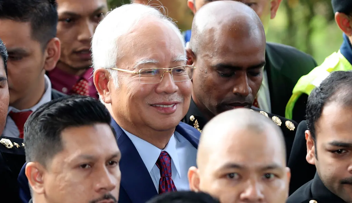 Mantan Perdana Menteri Malaysia, Najib Razak  tiba di Pengadilan Kuala Lumpur, Rabu (4/7). Najib Razak akan menghadapi dakwaan ganda terkait skandal penyelewengan dana lembaga investasi 1 Malaysia Development Berhad (1MDB). (AP/Vincent Thian)