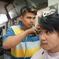 Gibran Rakabuming Raka di sela blusukan menyempatkan untuk potong rambut di tukang cukur Madura.(Liputan6.com/Fajar Abrori)