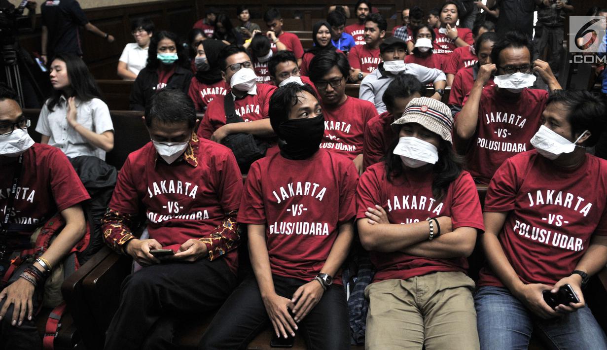 Aktivis Koalisi Inisiatif Bersihkan Udara Koalisi Semesta (Ibu kota) menghadiri sidang perdana gugatan polusi udara di Jakarta di PN Jakarta Pusat, Kamis (1/8/2019). Mereka mengenakan masker dan pakaian kaus berwarna merah bertuliskan "Jakarta vs Polisi Udara". (merdeka.com/Iqbal S Nugroho)