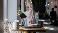 Ilustrasi Islami, muslimah, membaca buku, belajar hadis. (Foto oleh Mikhail Nilov: https://www.pexels.com/id-id/foto/restoran-orang-wanita-laptop-7582414/)