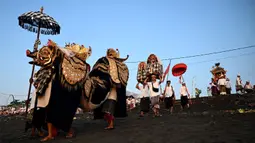 Saat upacara Melasti, segala sesuatu atau sarana sembahyang di Pura dibawa ke laut untuk disucikan. (SONNY TUMBELAKA/AFP)