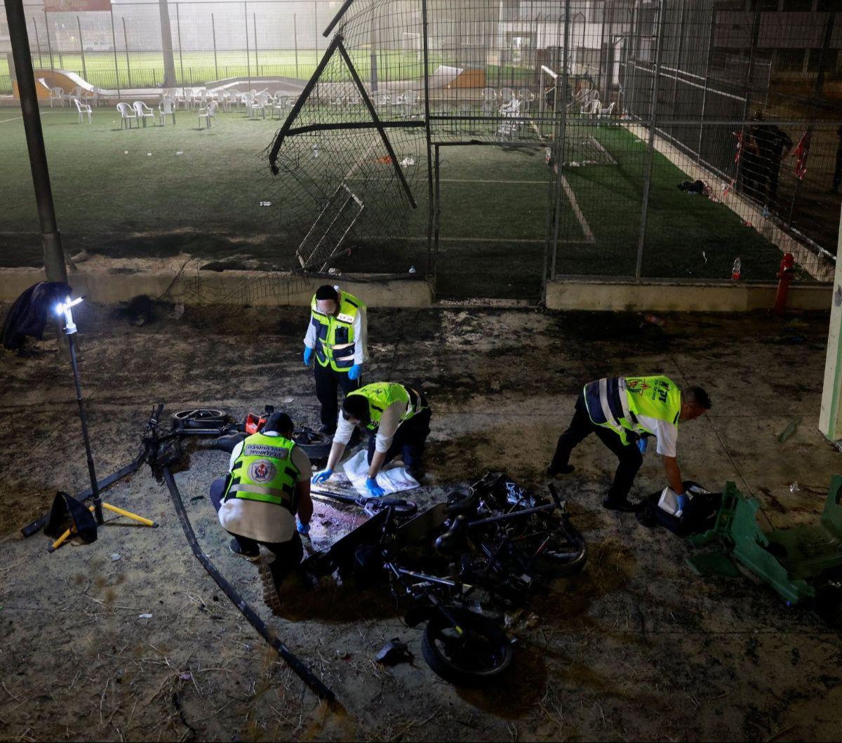 Petugas darurat memeriksa lokasi serangan roket di sebuah lapangan sepak bola di Desa Majdal Shams, Dataran Tinggi Golan yang diduduki Israel, pada Sabtu (27/7/2024). Serangan roket misteirus, yang dilaporkan berasal dari Lebanon, tersebut menewaskan sed