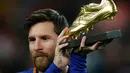 Pemain bintang Barcelona, Lionel Messi memamerkan Sepatu Emasnya sebelum pertandingan melawan Deportivo La Coruna dalam liga Spanyol di stadion Camp Nou di Barcelona (17/12). (AP Photo/Manu Fernandez)