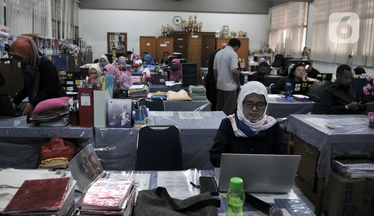 Guru membuat materi pelajaran daring di ruang guru SMP Negeri 92, Jakarta, Senin (16/3/2020). Pemprov DKI menutup kegiatan belajar mengajar di sekolah selama dua pekan dan menerapkan online home learning sebagai langkah mengatisipasi penyebaran virus corona COVID-19. (merdeka.com/Iqbal Nugroho)