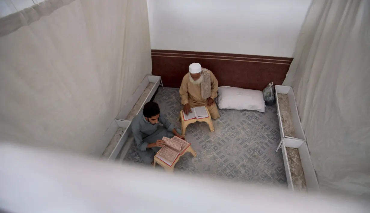 <p>Umat Muslim membaca al-Quran saat melakukan ibadah itikaf di sebuah masjid, di Peshawar , Pakistan, 22 April 2022. Itikaf adalah adalah tinggal atau menetap di dalam masjid dengan niat beribadah untuk mendekatkan diri kepada Allah dan biasanya dilakukan sepuluh hari terakhir Ramadhan. (AP Photo/Muhammad Sajjad)</p>