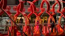 Seorang wanita berpose untuk berfoto di sebuah jembatan bertema Imlek di sebuah pusat perbelanjaan kelas atas di Beijing (21/2). Rabu (22/2) adalah hari terakhir liburan selama perayaan Imlek di China. (AP Photo / Mark Schiefelbein)