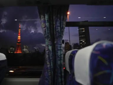 Menara Tokyo terlihat melalui jendela bus menjelang Olimpiade Musim Panas 2020 di Tokyo pada 15 Juli 2021. Di bawah protokol yang ketat, satu-satunya cara untuk melihat sekilas ibu kota adalah dari kendaraan yang mengantar para tamu dari perkampungan atlet atau hotel ke venue. (AP Photo/Jae C Hong)