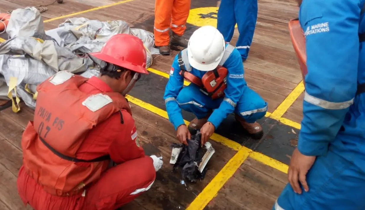 Awak kapal Pertamina mengamati serpihan pesawat Lion Air bernomor penerbangan JT-610 rute Jakarta-Pangkalpinang yang jatuh di perairan Tanjung Karawang, Jawa Barat, Senin (29/10). (HO/NATIONAL DISASTER MITIGATION AGENCY/PERTAMINA HULU ENERGY / AFP)