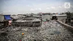 Suasana jembatan kayu di antara sampah di perkampungan nelayan Cilincing, Jakarta, Minggu (21/2/2022). Peringatan HPSN 2022, Pemprov DKI Jakarta mengajak warga Jakarta untuk peduli sampah mulai dari lingkungan terdekat minimal dengan cara memilah sampah dari rumah. (Liputan6.com/Faizal Fanani)