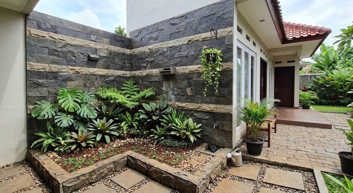 Model dinding belakang rumah dengan kombinasi batu alam dan tanaman model dengan taman sudut