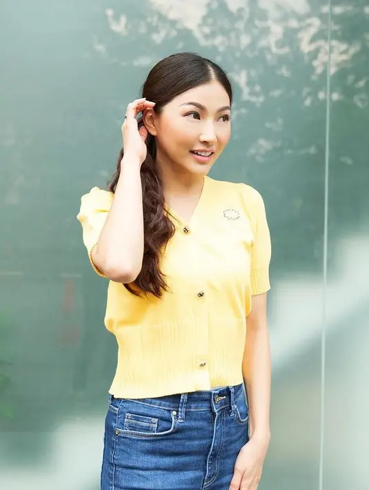 Sarwendah tampil simpel dengan knitted top berwarna kuning. Outfit cerah ini dipadukan dengan blue jeans skirt. (instagram/sarwendah29)