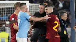 Pemain Lazio, Adam Marusic, bersitegang dengan pemain  AS Roma, Gianluca Mancini, pada laga pekan ke-27 Serie A 2022/2023 di Stadion Olimpico, Senin (20/03/2023). Total ada tiga kartu merah dikeluarkan wasit di laga panas ini. (AP Photo/Gregorio Borgia)