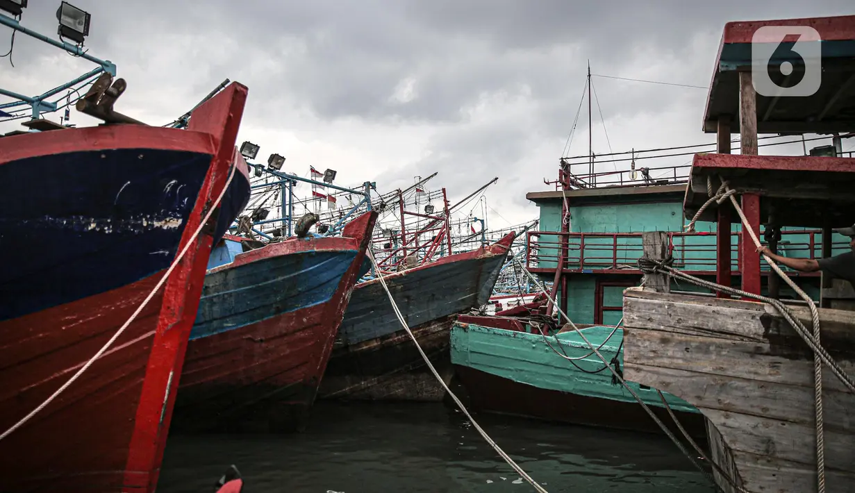 Sejumlah perahu saat bersandar di Pelabuhan Muara Angke, Jakarta, Senin (26/12/2022). Akibat angin  barat dan gelombang tinggi menyebabkan nelayan tradisional di Muara Angke libur melaut. (Liputan6.com/Faizal Fanani)