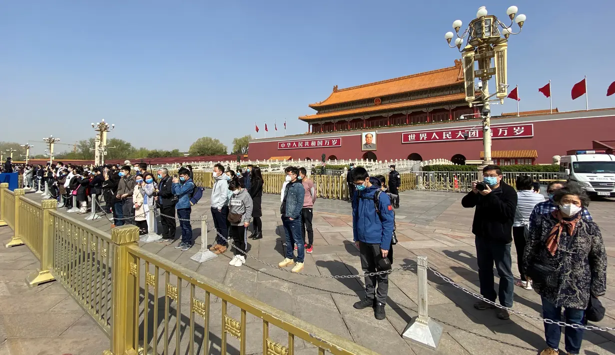 Orang-orang membungkuk di depan Gerbang Tiananmen di Beijing selama peringatan nasional tiga menit untuk memperingati orang yang meninggal dalam wabah coronavirus COVID-19, di Beijing (4/4/2020). (AFP/Leo Ramirez)