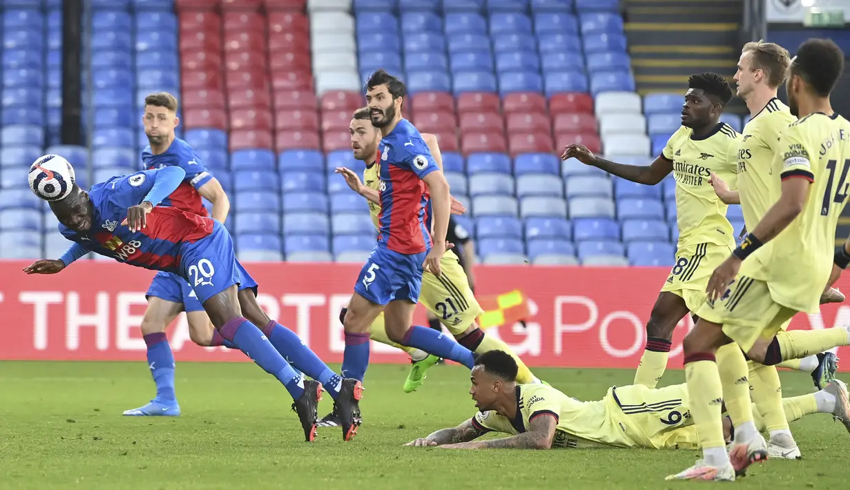 Striker Crystal Palace, Christian Benteke (kiri) melepaskan sundulan yang berbuah gol ke gawang Arsenal dalam laga lanjutan Liga Inggris 2020/2021 pekan ke-37 di Selhurst Park, London, Rabu (19/5/2021). Crystal Palace kalah 1-3 dari Arsenal. (AP/Justin Setterfield/Pool)