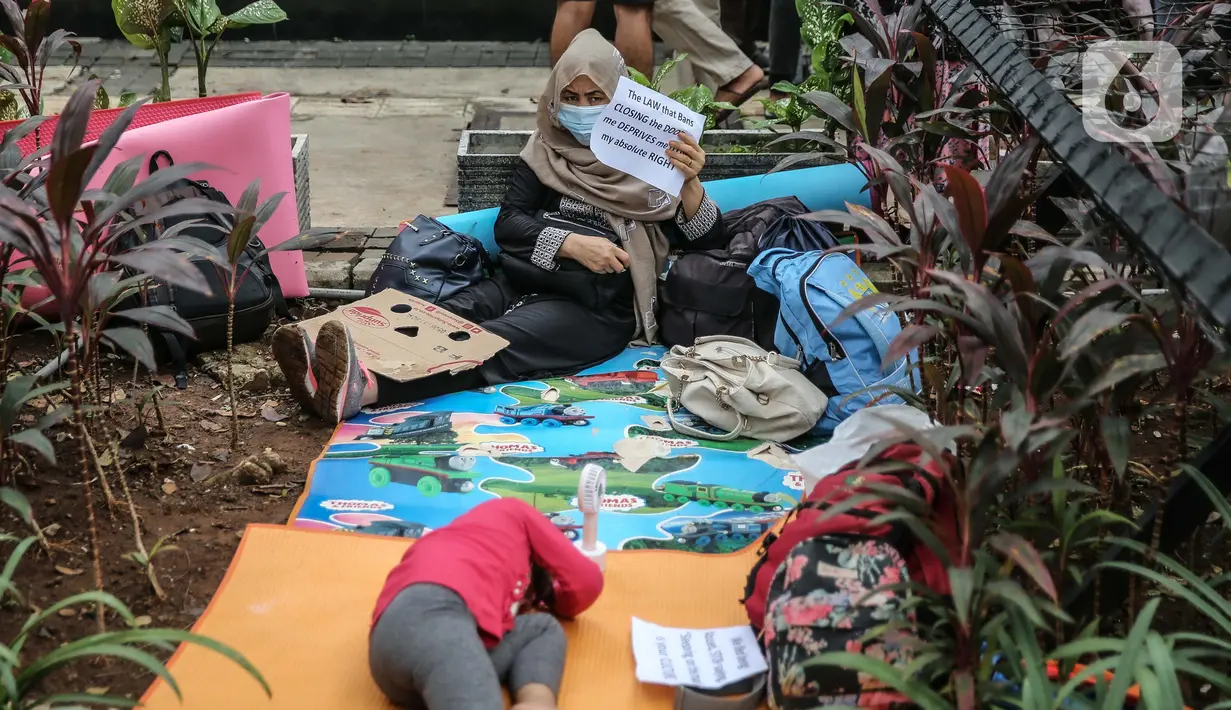 Para pencari suaka beristirahat saat aksi unjuk rasa di depan kantor UNHCR, Jakarta, Selasa (18/8/2020). Dalam aksinya mereka meminta pertanggung jawaban dari UNHCR karena hingga saat ini banyak para pencari suaka tidak mendapatkan kejelasan akan nasibnya di Indonesia. (Liputan6.com/Faizal Fanani)