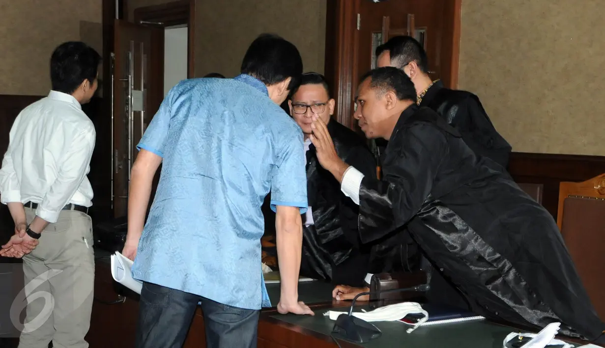 Presdir Agung Podomoro Land. yang menjadi tersangka kasus suap Raperda reklamasi Teluk Jakarta, Ariesman Widjaja berdiskusi dengan kuasa hukumnya saat sidang perdana di Pengadilan Tipikor, Jakarta, Kamis (23/6). (Liputan6.com/Helmi Afandi)