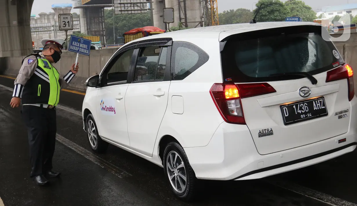 Petugas kepolisian memeriksa kendaraan yang melintasi Pos Penyekatan Jalur Mudik di Gerbang Tol Cikarang Barat, Kabupaten Bekasi, Senin (18/5). Memasuki H-6 Lebaran, puluhan kendaraan diminta untuk putar balik karena melanggar larangan mudik yang ditetapkan pemerintah. (Liputan6.com/Herman Zakharia)